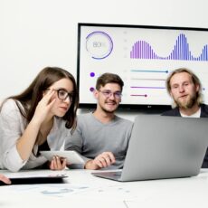 man and woman sitting at table with macbook