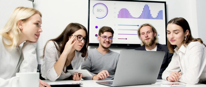 man and woman sitting at table with macbook